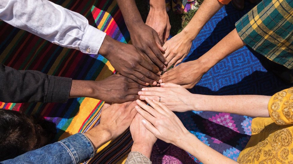 Diverse group of people from different ethnic backgrounds puttin dłonie ludzi