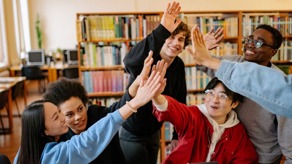 Zdjęcie grupy studenckiej - przebijają "piątkę"